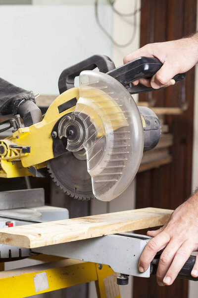 carpenter cutting with electric sawdust