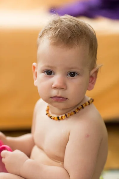 赤ちゃん幼児の身に着けているネックレス琥珀歯の痛みを軽減 — ストック写真