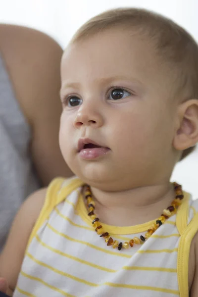 赤ちゃん幼児の身に着けているネックレス琥珀歯の痛みを軽減 — ストック写真