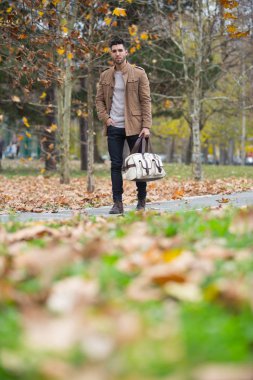 Genç yetişkin adam ahşap, kış sonbahar gün yürüyüş yakışıklı