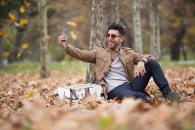 Genç yetişkin adam yakışıklı alarak selfie ahşap, kış sonbahar günü içinde