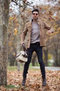 Genç yetişkin adam ahşap, kış sonbahar gün atlama yakışıklı