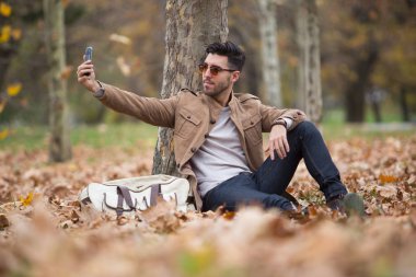 Genç yetişkin adam yakışıklı alarak selfie ahşap, kış sonbahar günü içinde