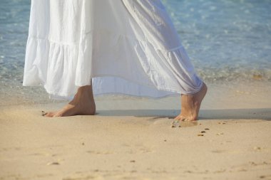 sahilde yürüyen yalınayak kadın