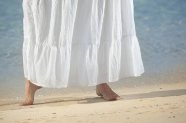 sahilde yürüyen yalınayak kadın