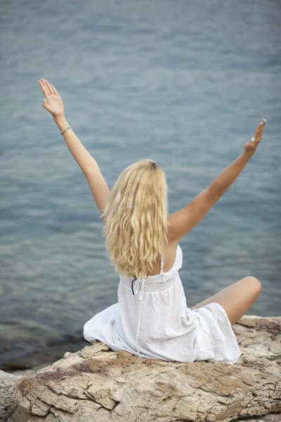 Woman practicing yoga and relaxing on the beach — Stock Photo, Image