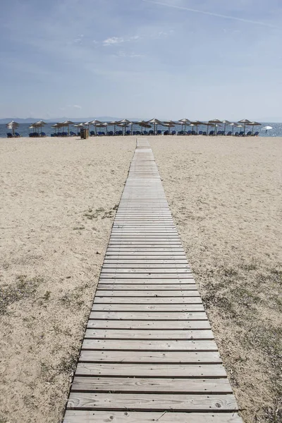 Wooden boards ,walkway for beutiful sand beach with sun-beds Royalty Free Stock Photos