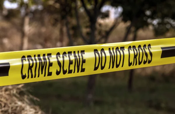 Crime scene tape closeup, police tape Do Not Cross outdoors