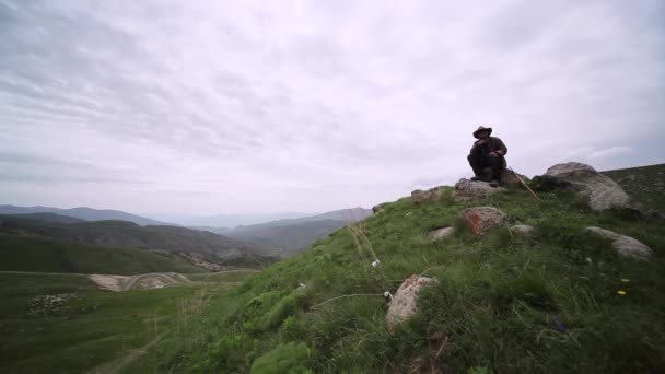 Człowiek Siedzący Szczycie Góry Obserwujący Pola — Wideo stockowe