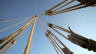 Aşağıdan görünen bir yelkenli direği, eski geminin halatları ve halatları.