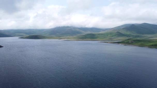 Letecký Dron záběr jezera, obklopen kopci a horami. — Stock video