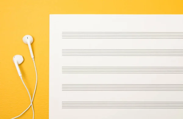 White Earphones Blank Music Paper Sheet Vibrant Yellow Background — Stock Photo, Image