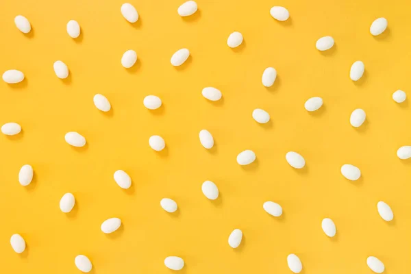 Weiße Schokoladenbonbons Auf Fröhlichem Leuchtend Gelbem Hintergrund Verstreut — Stockfoto