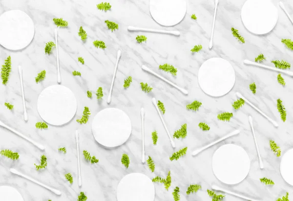 Pads Βαμβάκι Tips Και Πράσινα Φύλλα Μαρμάρινο Φόντο Επίπεδη Lay — Φωτογραφία Αρχείου