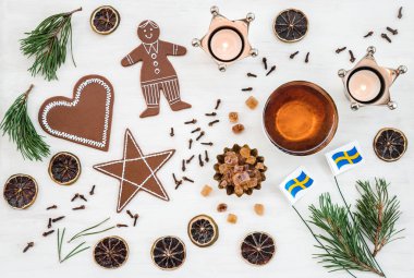Bayrakları, mumlar, çay fincanı, zencefilli bisküvi ve baharatlar ile İsveçli Noel dekor.