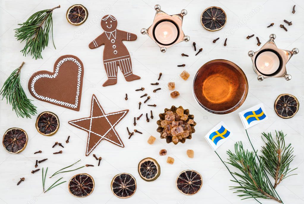 Swedish Christmas decor with flags, candles, teacup, ginger biscuits and spices.