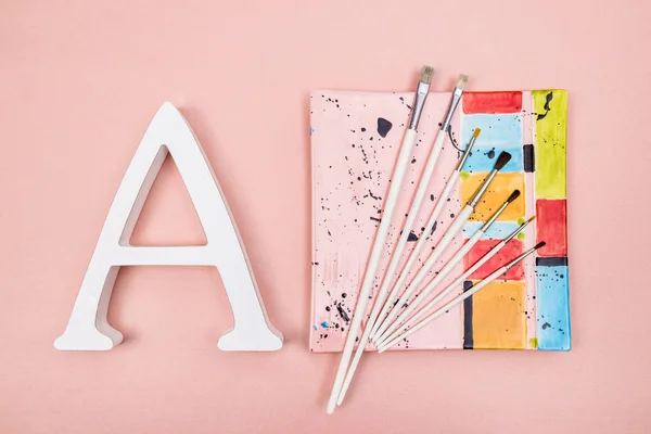 Carta Pincéis Brancos Uma Placa Cerâmica Colorida Sobre Fundo Rosa — Fotografia de Stock