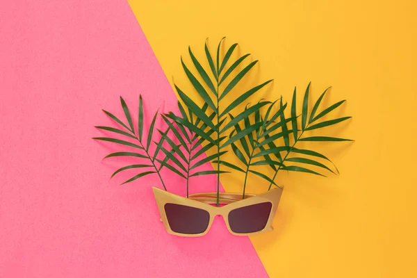 Hojas Palmera Gafas Sol Sobre Vibrante Fondo Rosa Amarillo Tema —  Fotos de Stock