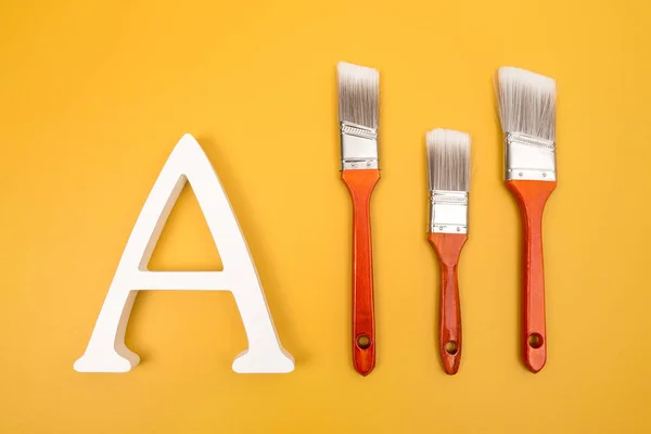 Letter Three Red Paintbrushes Yellow Background Art Renovation Project — Stock Photo, Image