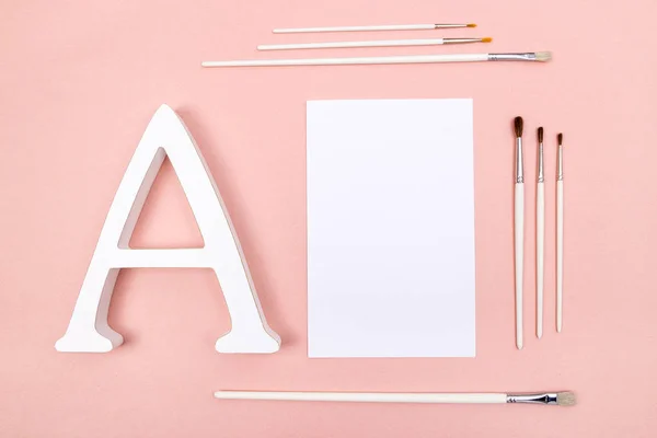 Hoja Papel Blanco Letra Pinceles Blancos Sobre Fondo Rosa Pastel —  Fotos de Stock