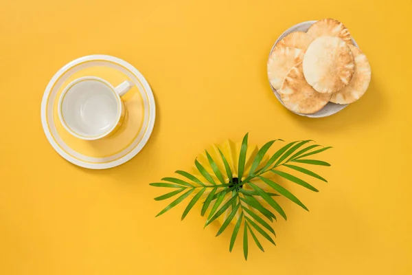 Çay Fincanı Palmiye Yaprakları Parlak Sarı Zemin Üzerine Ekmek Tabağı — Stok fotoğraf