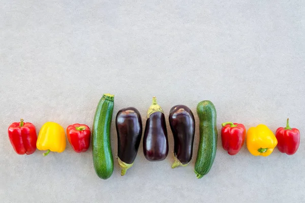 Fila Vegetais Coloridos Verão Fundo Concreto Pimentos Vermelhos Amarelos Abobrinhas — Fotografia de Stock