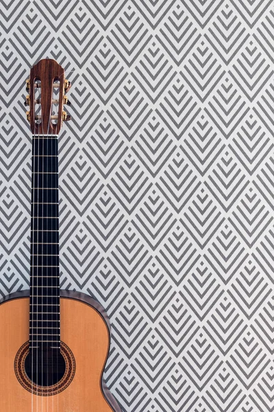 Geometrik Duvar Kağıdı Ile Bir Duvarının Yakınında Bir Klasik Gitar — Stok fotoğraf