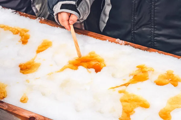Akçaağaç taffy üzerinde tahta bir sopa koyarak çocuk 