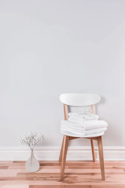 Белые полотенца на стуле в светлом интерьере — стоковое фото