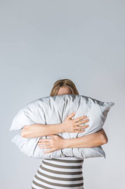 Young woman hugging a gray pillow clipart