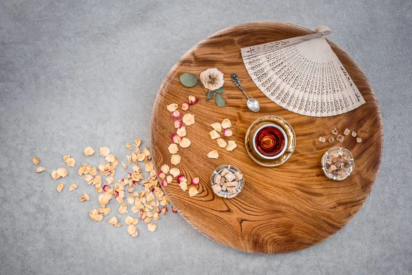 Mesa de madeira vintage com chá e pétalas de rosa — Fotografia de Stock