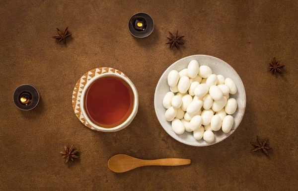 Tea and almonds in white chocolate — Stock Photo, Image