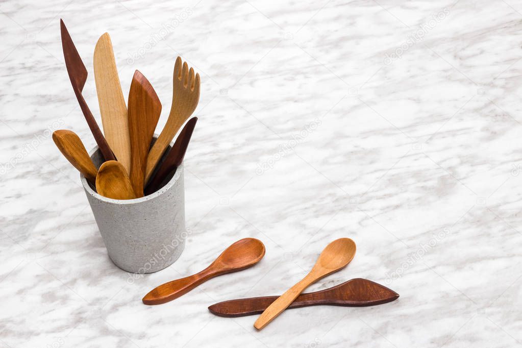 Handcrafted wooden utensils in a concrete cup