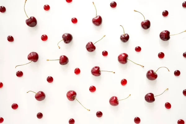 Sweet cherries and cherry candies on white background