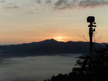 Bulutlar ve sis kaplı dağın başında.