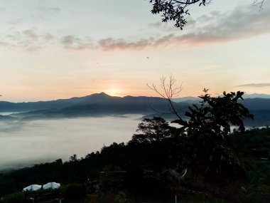 Bulutlar ve sis kaplı dağın başında.