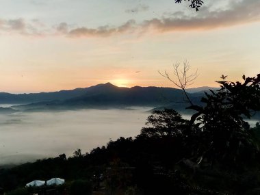 Bulutlar ve sis kaplı dağın başında.