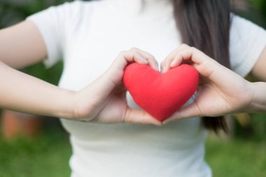 Kadının ellerini dikkatle güzel doğru manikür ile kırmızı kalp.