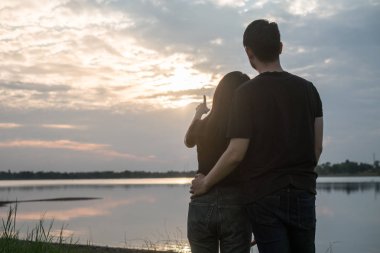 Ayakta, birbirlerine sarılma ve s izlerken romantik çiftler