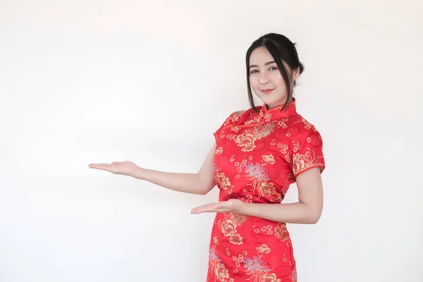 亚洲妇女在传统的中国旗袍礼服与一个欢迎的姿态在白色的背景 女人举起手来建议一些事情 — 图库照片