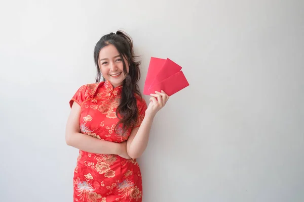 亚洲妇女穿着中国传统旗袍礼服 并为中国新年展示红包 — 图库照片