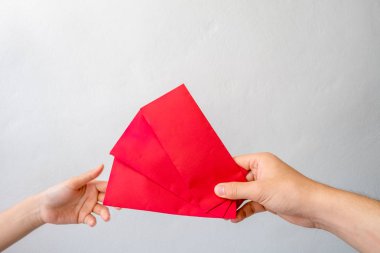 Angpang zarf tutmak adamların elleri genç kadını bir Çince yılbaşı günü hediyesi olarak duruyorsun.