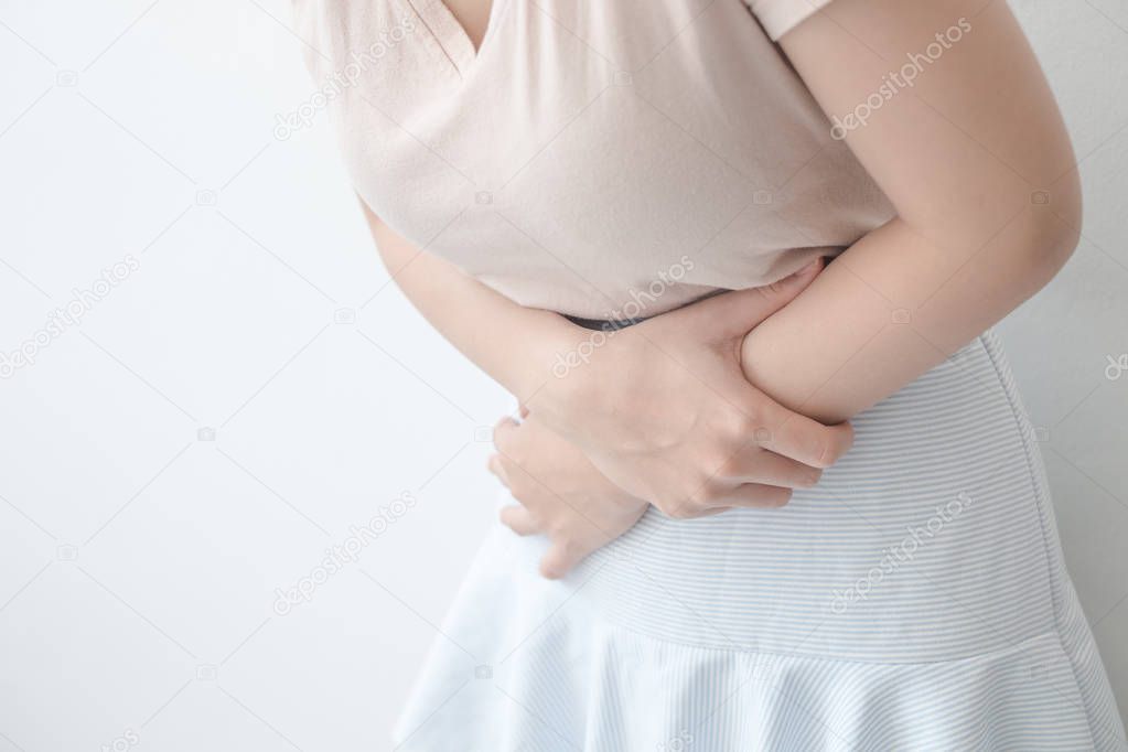 Women with abdominal pain standing, holding the body and hands P