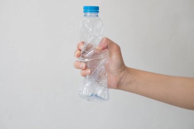 beyaz zemin üzerinde bir geri dönüşümlü plastik şişe tutan el. 