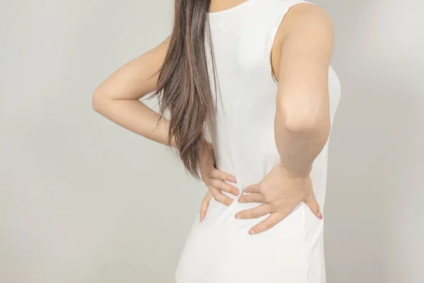Eine Frau hielt ihre Hand mit Rückenschmerzen hinter sich. Gesundheitswesen — Stockfoto