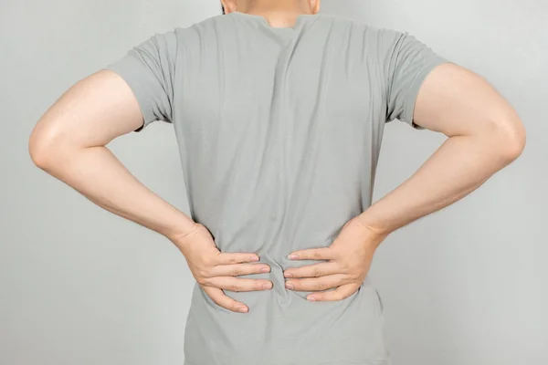 Een man hield haar hand achter hem met rugpijn. Gezondheidszorg Fien — Stockfoto