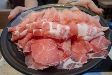 Bir dilim domuz eti tutan kadınlar yemeye hazır.