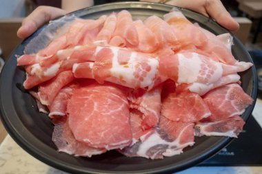 Bir dilim domuz eti tutan kadınlar yemeye hazır.