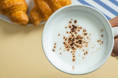 sarı bir arka planda kruvasanlar ve sıcak süt, üst görünüm, breakfas