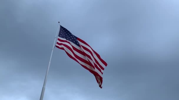 風の強い灰色の曇り空の日に完全なスタッフを飛んでアメリカ国旗 — ストック動画